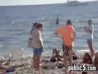 Marrjenëgojë në publike në the plazh